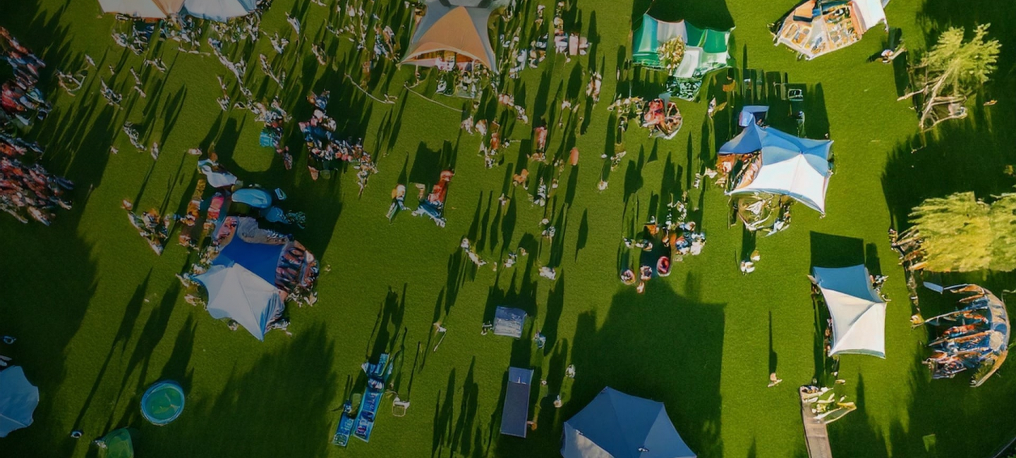 View of a climbing festival from a drone angle, green grass and tents as stand